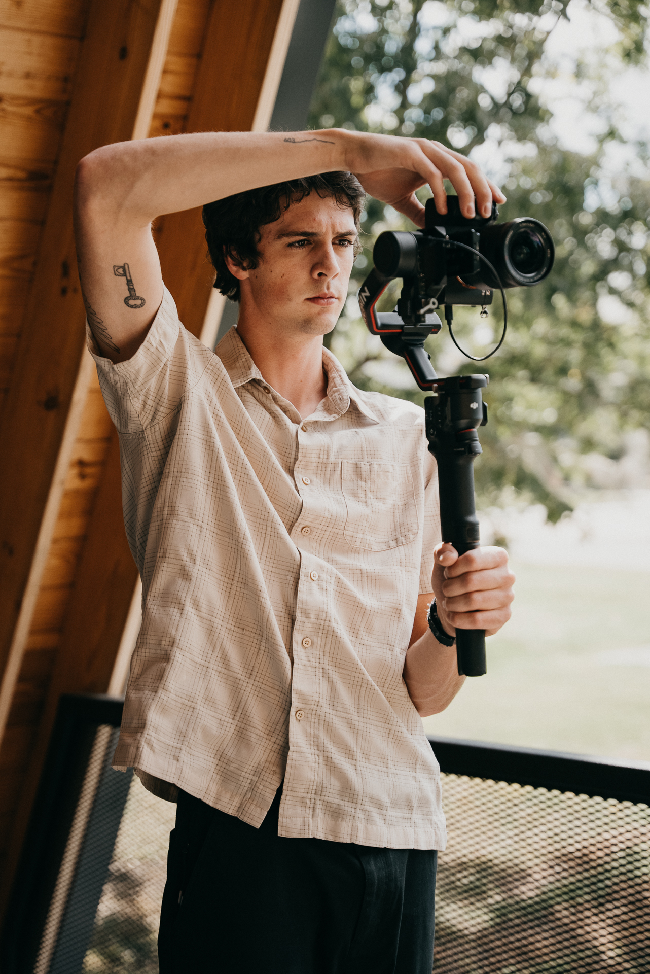 Videographer shooting an A-frame property with a gimbal-mounted camera
